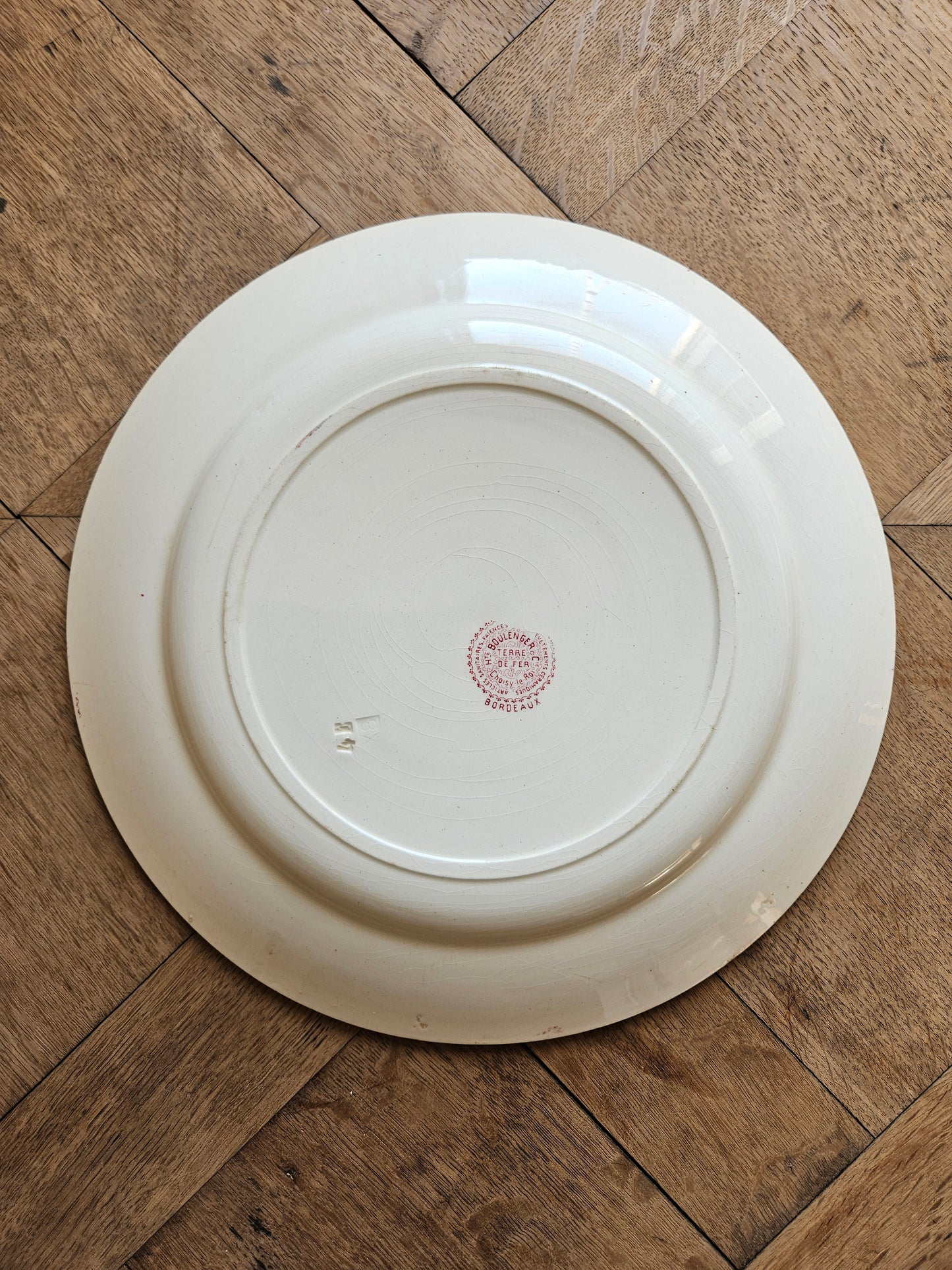 Plat rond ancien en terre de fer Hippolyte Boulenger Choisy-le-Roi, modèle Bordeaux rouge
