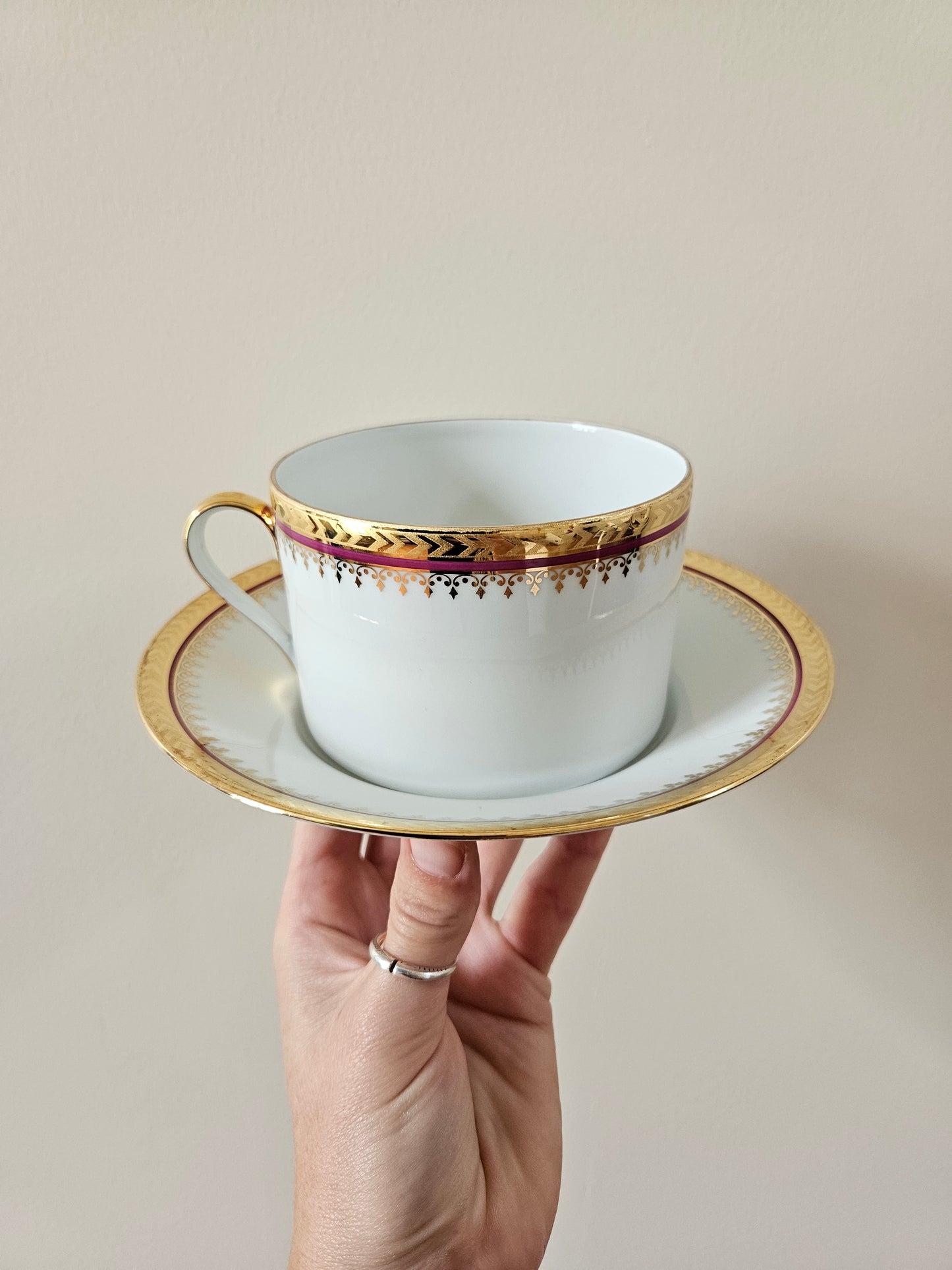Tasse et sous-tasse anciennes en porcelaine de Limoges, liseré rouge et dorure.