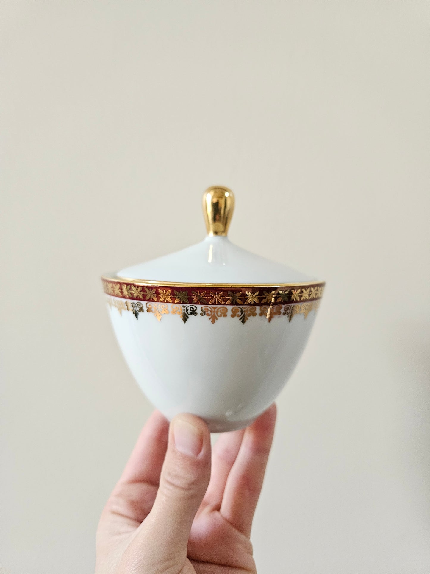 Sucrier vintage en porcelaine, décor rouge et doré. Élégance et raffinement.