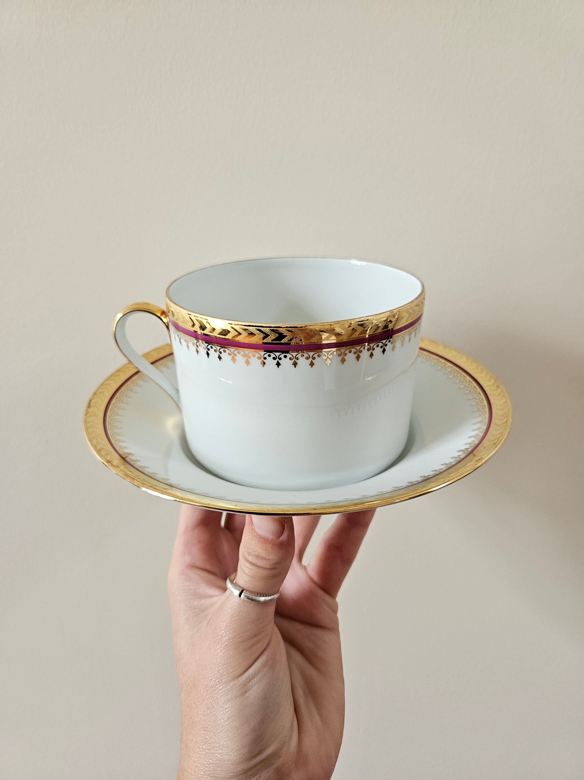 Tasse et sous-tasse anciennes en porcelaine de Limoges, liseré rouge et dorure.
