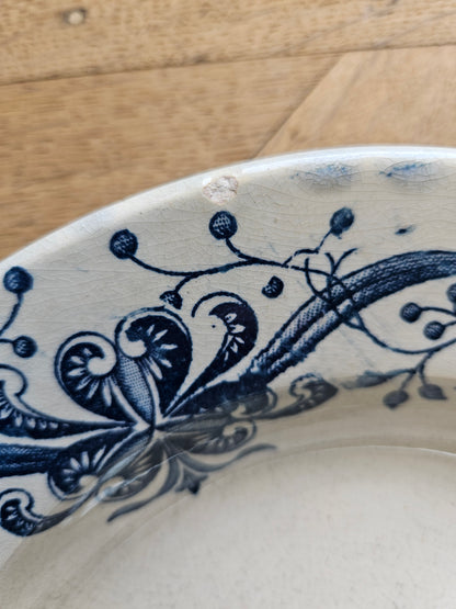 Assiette creuse ancienne patinée de la Faïencerie de Lyon, Joconde. Égrenure. 