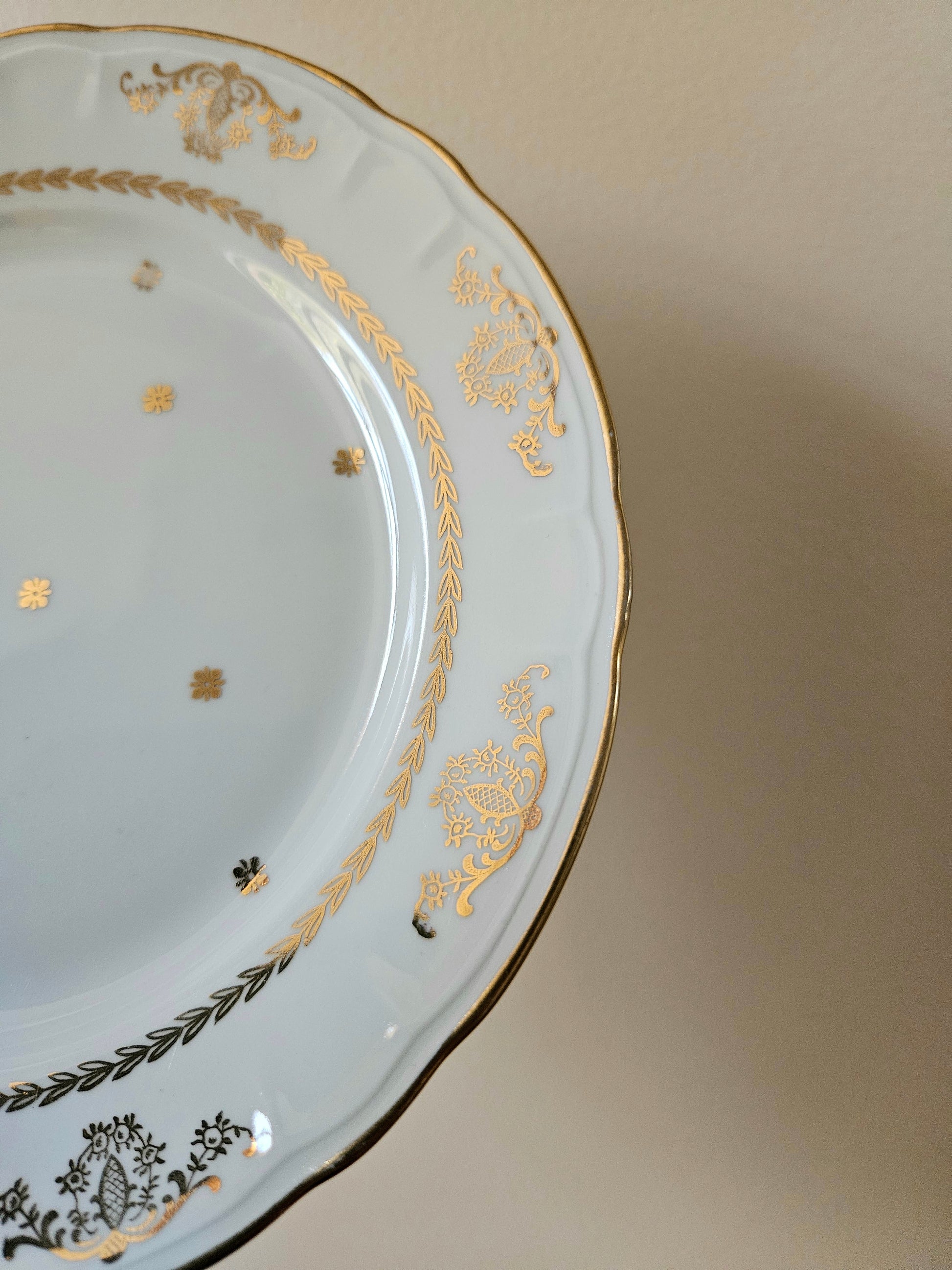 Élégant décor doré sur assiette ancienne en porcelaine. 