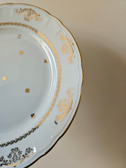 Élégant décor doré sur assiette ancienne en porcelaine. 