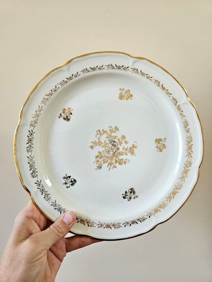 Assiette plate ancienne en porcelaine de Vierzon. Décor floral blanc et doré. Idéale pour une élégante table de fête. 