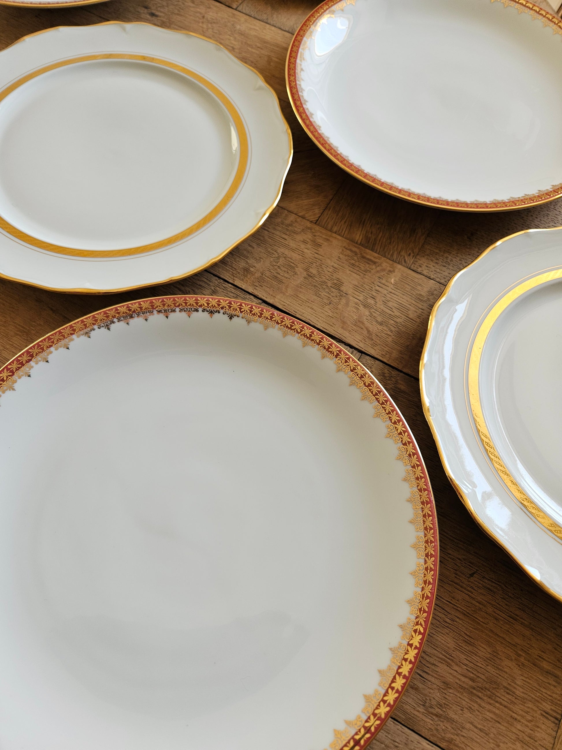 Mix and match d’assiettes plates vintage en porcelaine, rouges et dorées