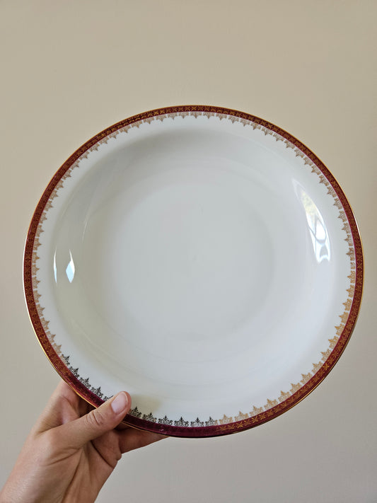 Plat creux vintage en porcelaine, décor rouge et or. Élégance et raffinement.