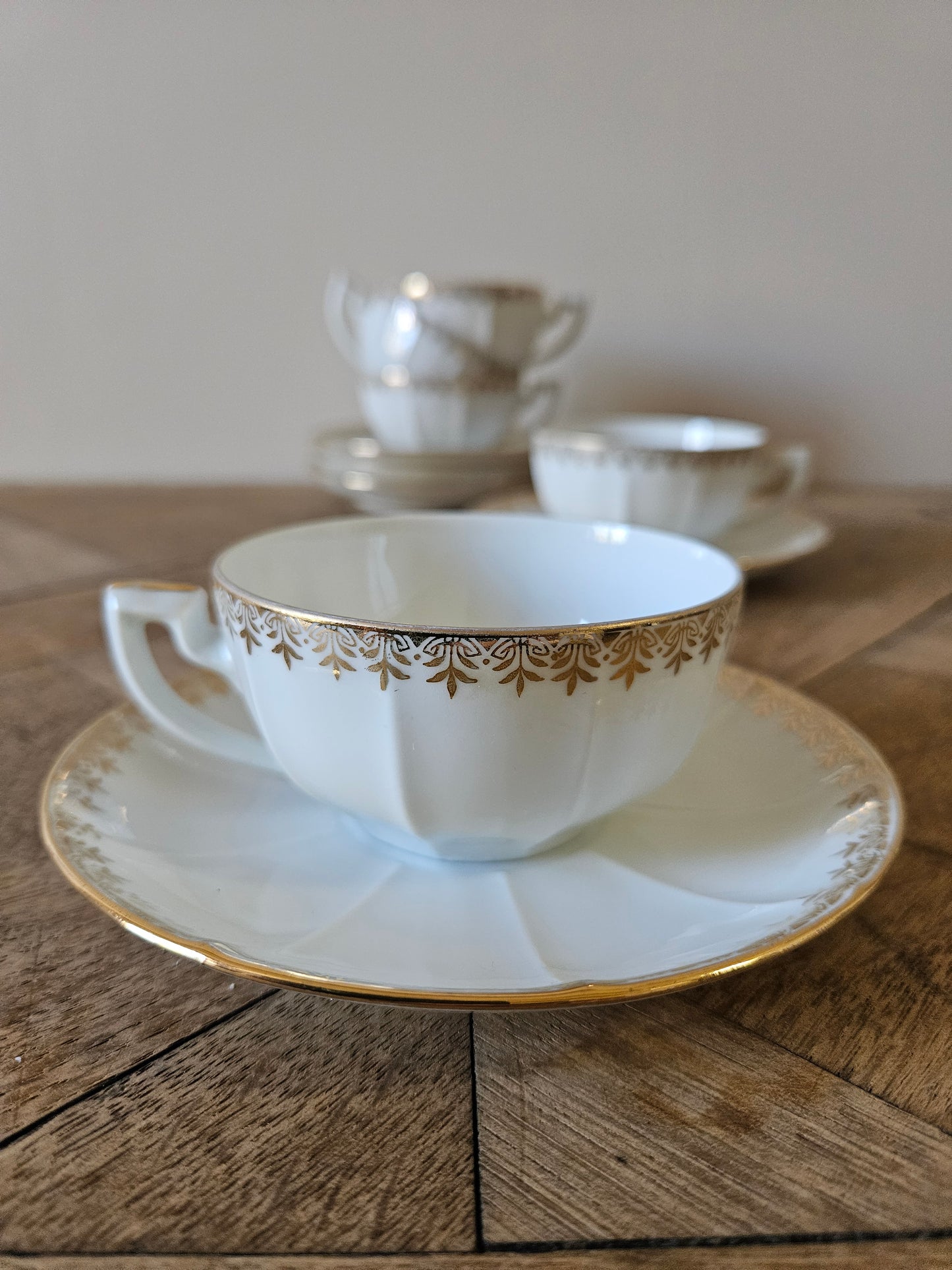 Tasse et sous-tasse anciennes en porcelaine du berry. Décor doré, forme à facettes.