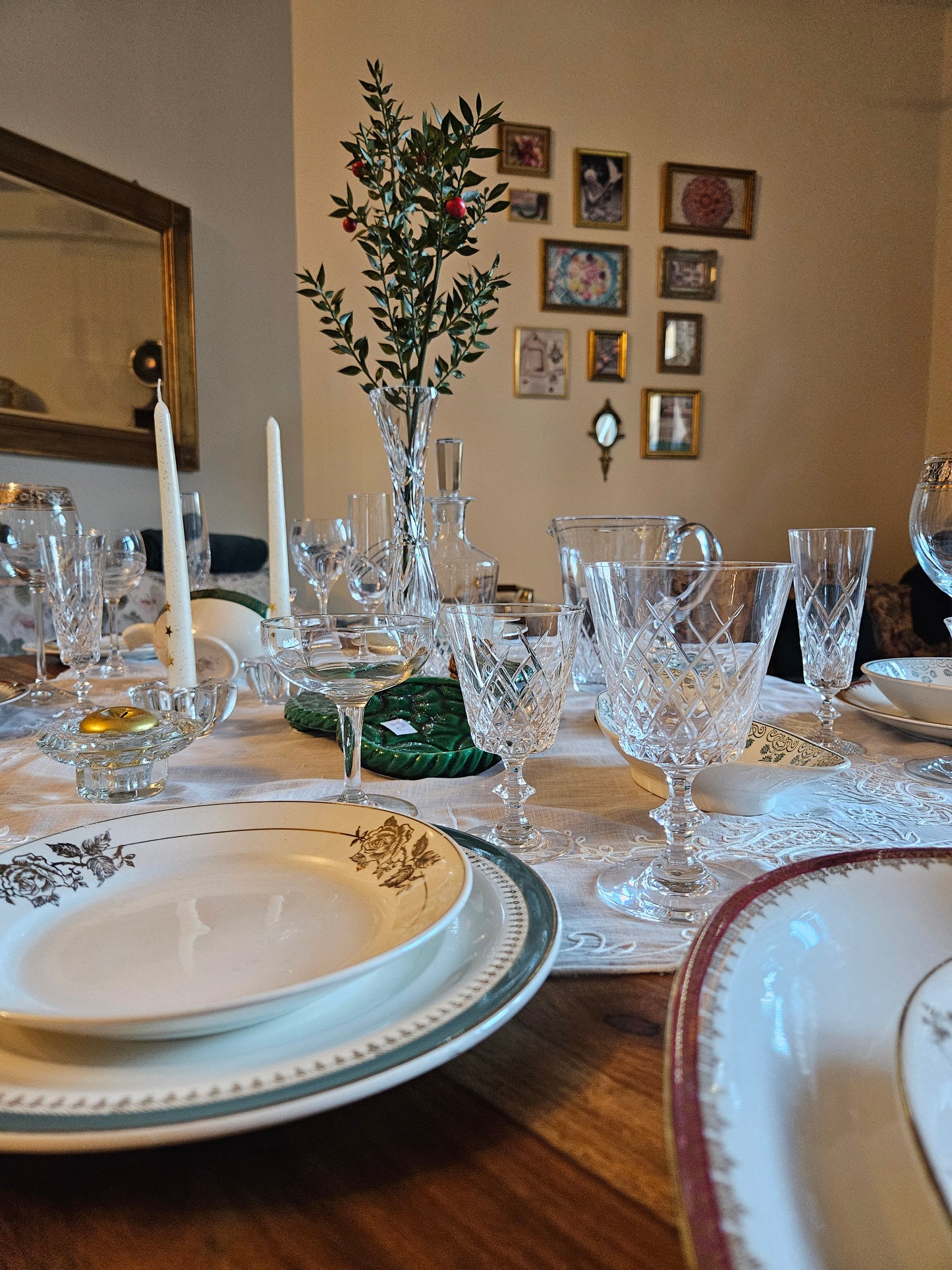 Table de fête vintage avec de la vaisselle ancienne. Assiettes dépareillées faïence et porcelaine. Verres et coupes à champagne, cristal. Art de la table ancien.