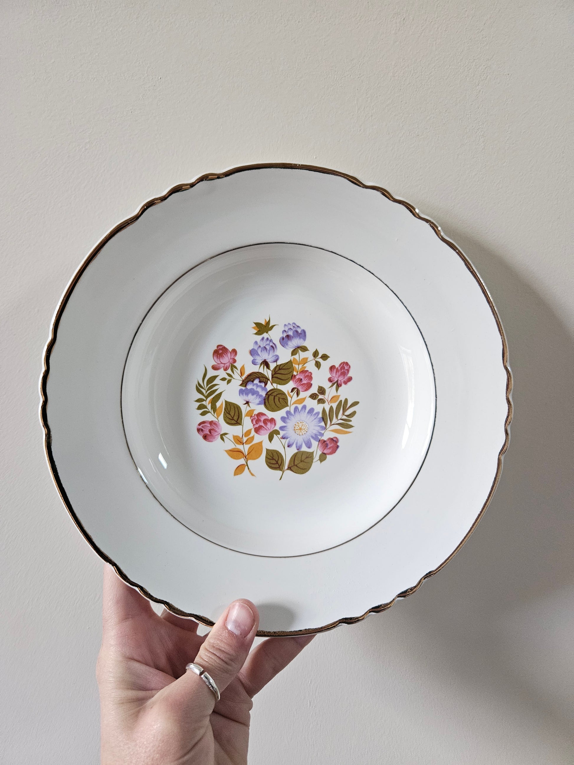 Assiette creuse vintage Moulin des Loups. Décor fleuri rose, violet et orange.