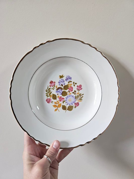 Assiette creuse vintage Moulin des Loups. Décor fleuri rose, violet et orange.